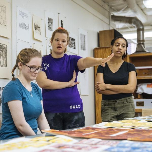 Three Agnes Scott studio 艺术 major students observe pieces of 艺术 in class.
